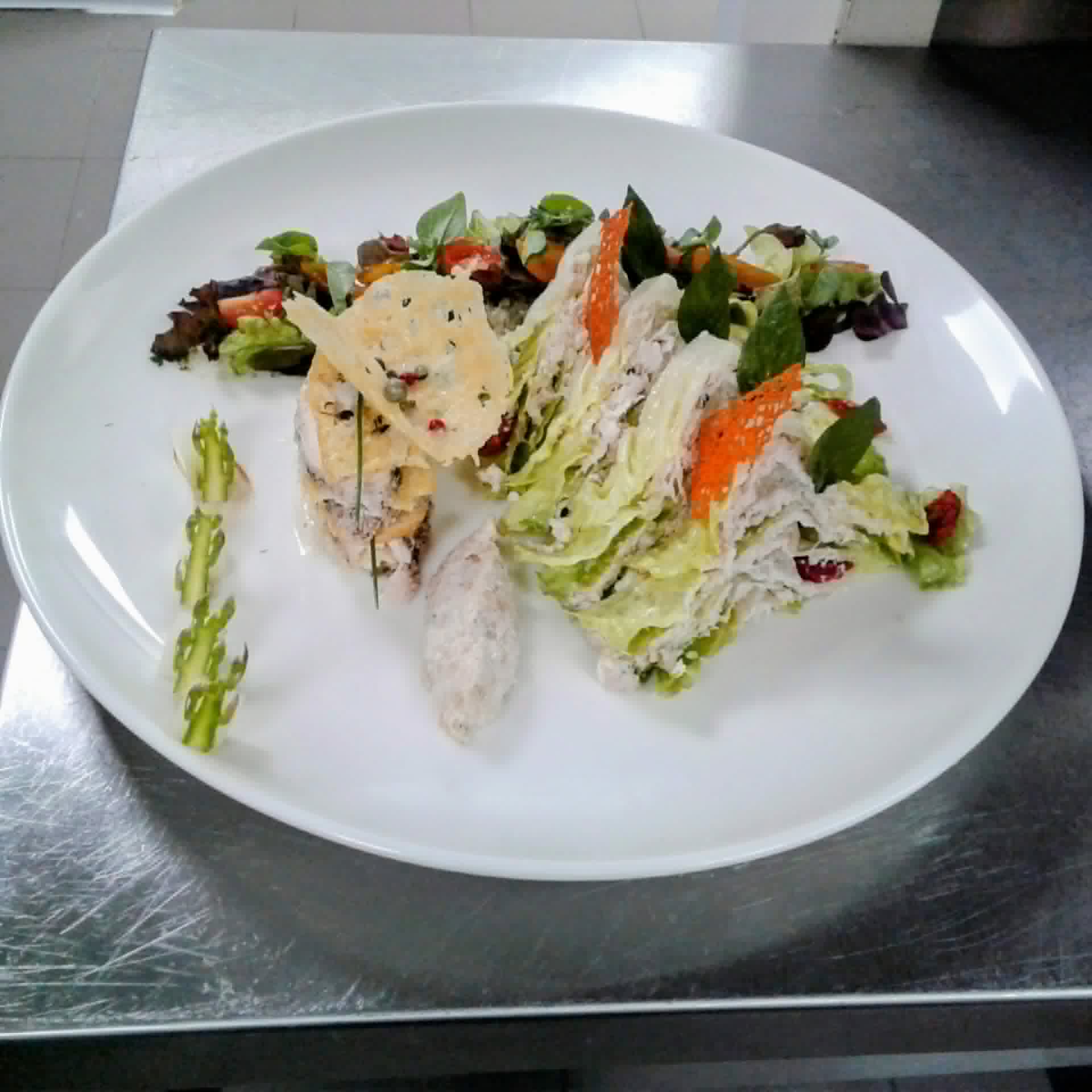 A composed salad plated kitchen-side